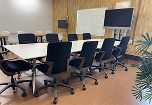 社内の休憩スペースの写真。観葉植物や大き目のテーブルとTVが設置されている