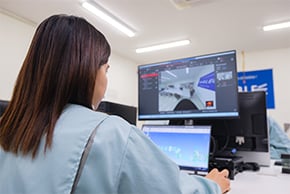 女性社員がPCモニターに向かって仕事をしている写真